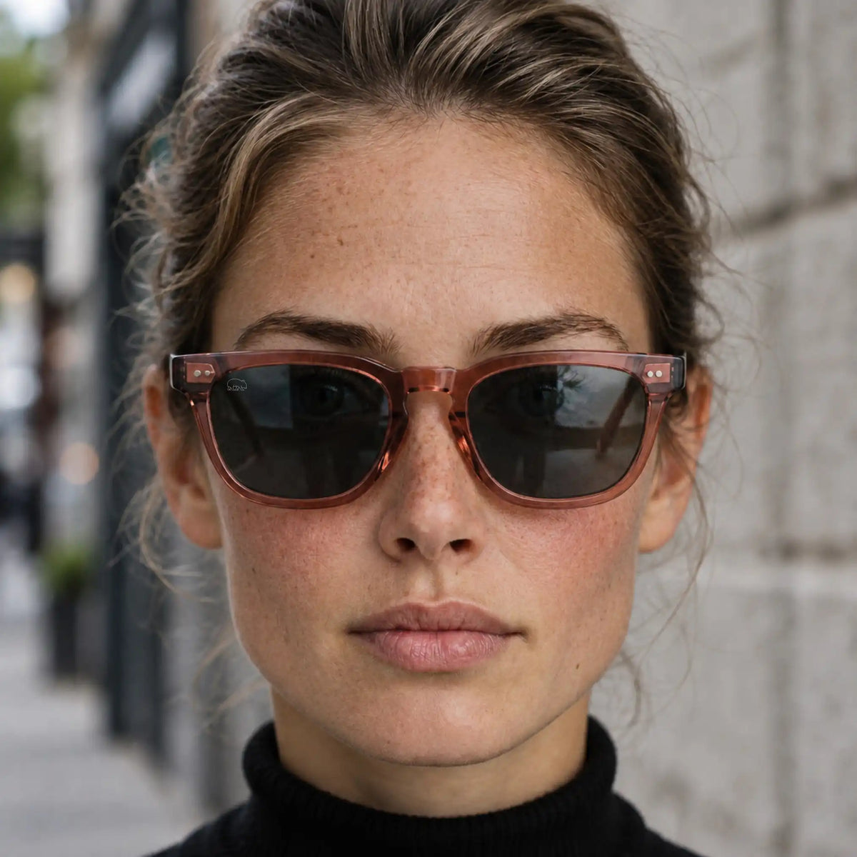 woman with berry coloured sunglasses on looking into the camera